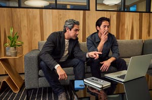 Two executives considering AB test results on a laptop