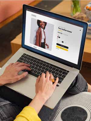 Woman holding a laptop on her lap shopping online