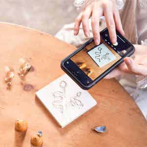 Person taking of their work with a smartphone